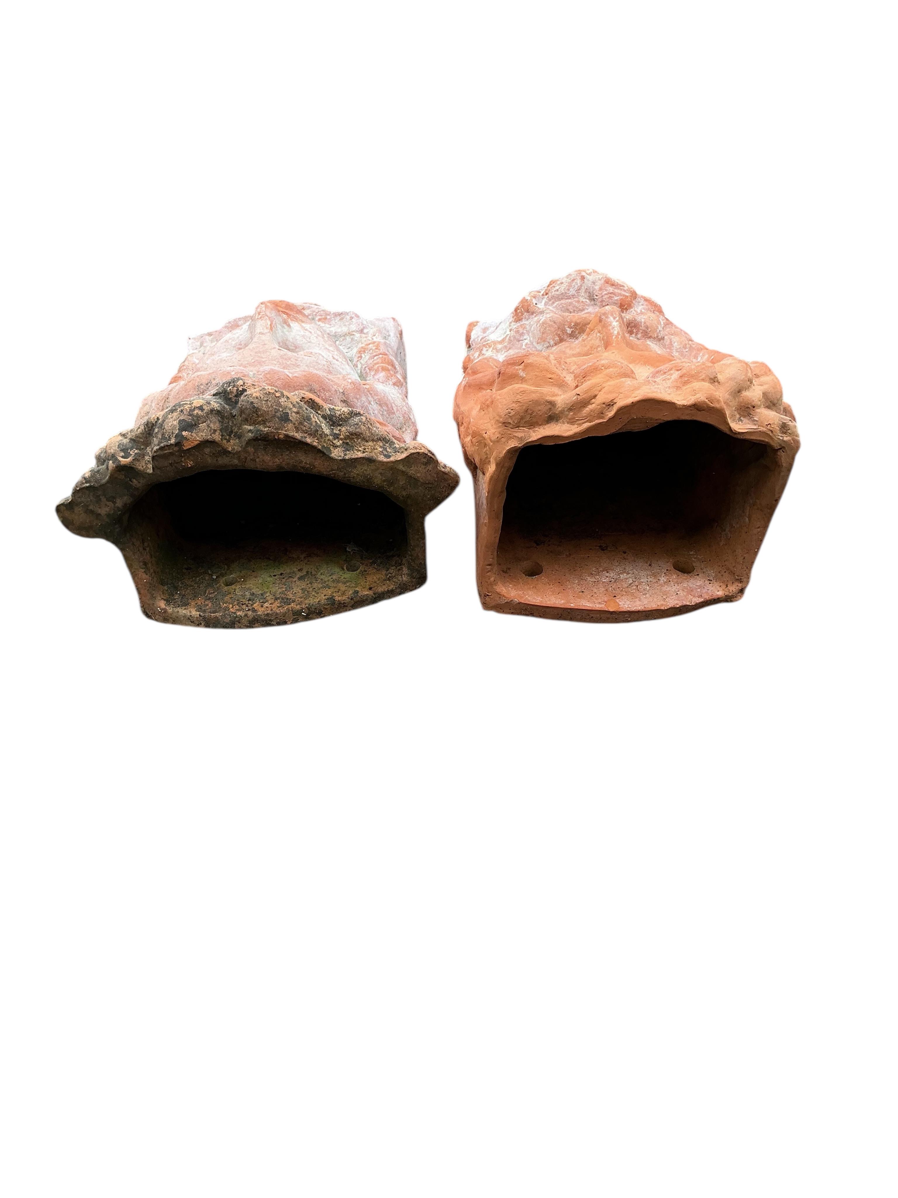 A pair of terracotta mask wall pockets, height 44cm